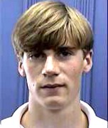 Unsmiling teenage boy with light brown hair